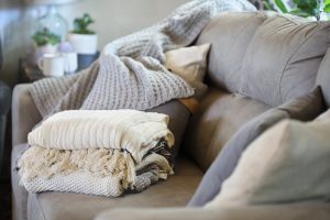 Colocar la manta doblada sobre el sofá